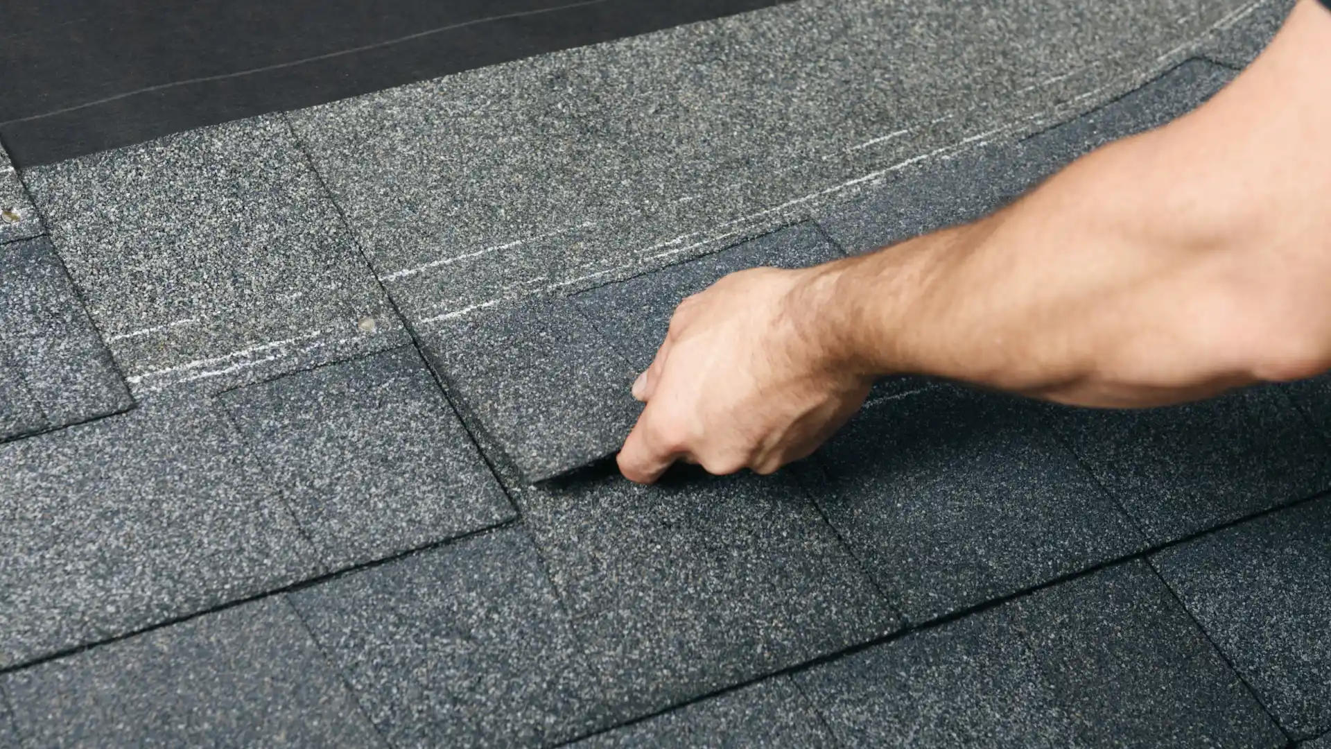 close up of a roofing contractor placing a shingle sheet during roofing installation aberdeen wa